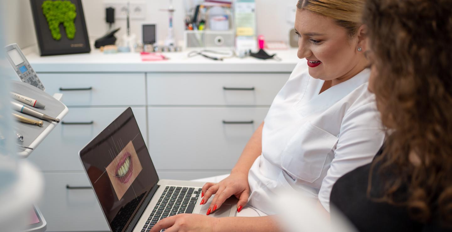 a woman sitting at a table using a laptop computer